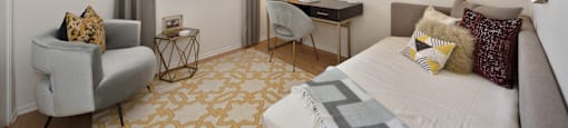 a bedroom with a bed and a chair and a desk