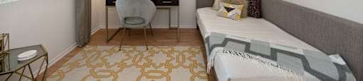 a bedroom with a bed and a desk with a chair