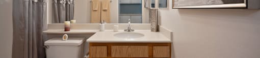 a bathroom with a toilet sink and mirror and a shower
