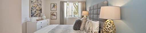 a bedroom with a bed and a dresser and a window