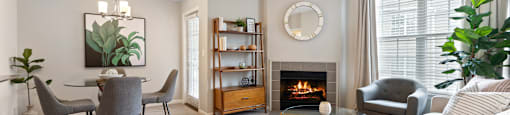 a living room with a fireplace and a table with chairs