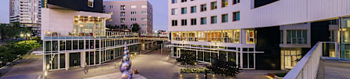 A modern building with a black and white exterior and a courtyard with a fountain in the center.
