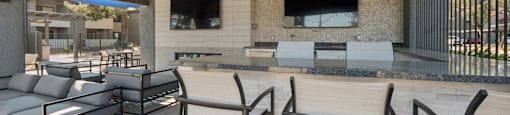a patio with a bar and chairs and a television