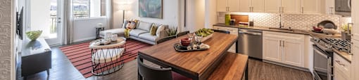 a kitchen and living room with a wooden table and chairs