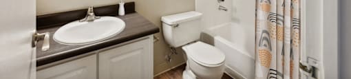 a bathroom with a shower toilet and sink and a shower curtain