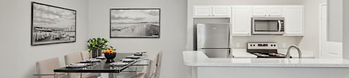 A kitchen with a bar stool and a dining table.