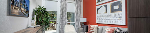 a living room with an orange accent wall and a gray couch