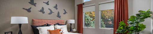 a bedroom with a bed and birds on the wall