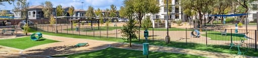 a dog park with a green grassy area and a playground