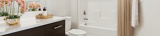 A white bathroom with a toilet, sink, and shower.