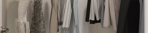 an image of a closet with clothes hanging on a rack