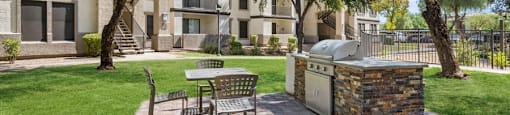a patio with a grill and a table and chairs