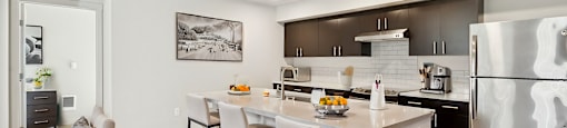 A modern kitchen with a dining table and chairs.
