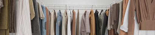 a rack of clothes and shoes in a closet