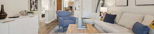 A living room with a white couch and a blue rug.