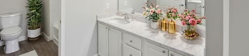 A white bathroom with a toilet, sink, and mirror.