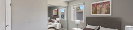 a bedroom with a bed and a couch and a window