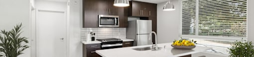 A modern kitchen with a curved island and bar stools.