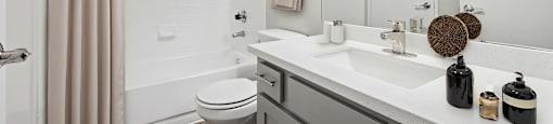 A bathroom with a toilet, sink, and shower.
