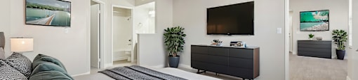 A bedroom with a large bed and a flat screen TV mounted on the wall.
