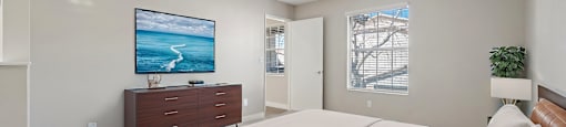 A bedroom with a large bed and a painting on the wall.
