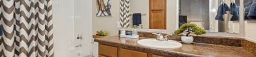 A bathroom with a brown counter top and a white toilet.