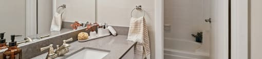 a bathroom with a sink and a shower and a mirror