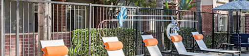 A poolside area with sun loungers and a table.