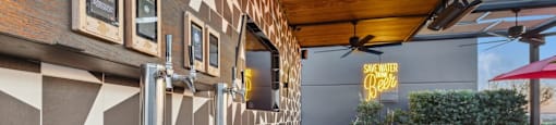A modern bar with a wooden floor and a metal counter.