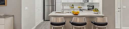 A modern kitchen with a bar stool at the island.