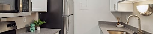 a kitchen with stainless steel appliances and white cabinets