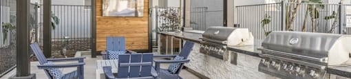 an outdoor patio with blue chairs and a grill and a tv