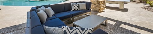A patio with a pool and a blue couch.