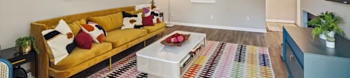a living room with a yellow couch and a television