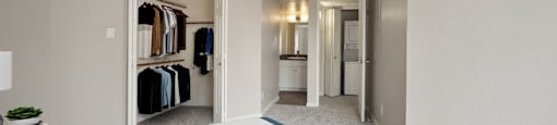a bedroom with a large bed and a closet with clothes racks