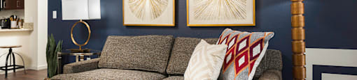 A living room with a grey couch, a wooden coffee table, and a lamp.