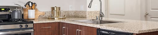 A kitchen with brown cabinets and a granite countertop.