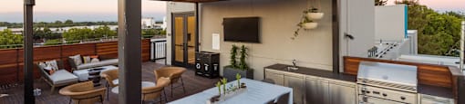 A modern outdoor kitchen with a dining table and chairs.