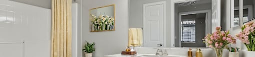 A bathroom with a white toilet, sink, and vanity.