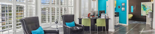 a living room with chairs and a table and a kitchen