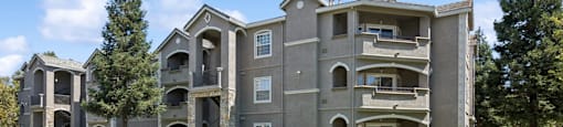 an apartment building with a green lawn and sidewalk