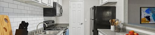 a kitchen with stainless steel appliances and white cabinets