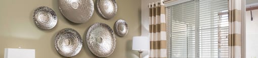 A living room with a sofa, armchair, and decorative wall pieces.