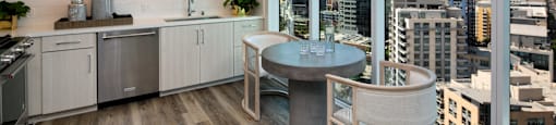 A modern kitchen with a table and chairs and a view of the city.