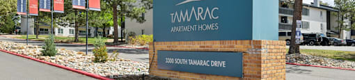 A sign for 3300 TamaraC Apartment Homes stands in front of a building.