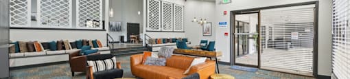 A modern office lounge with a variety of seating options and a patterned carpet.