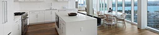 A modern kitchen with white appliances and wooden floors.