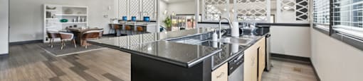 A modern kitchen with a black countertop and wooden flooring.