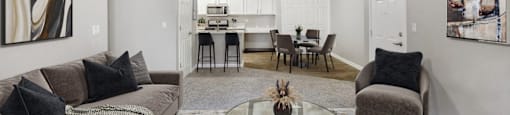 the living room and dining room of an apartment with couches and a table