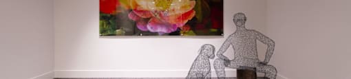 a sculpture of a man and a dog in a room with a painting of flowers